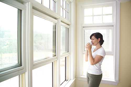 Woman standing by windows